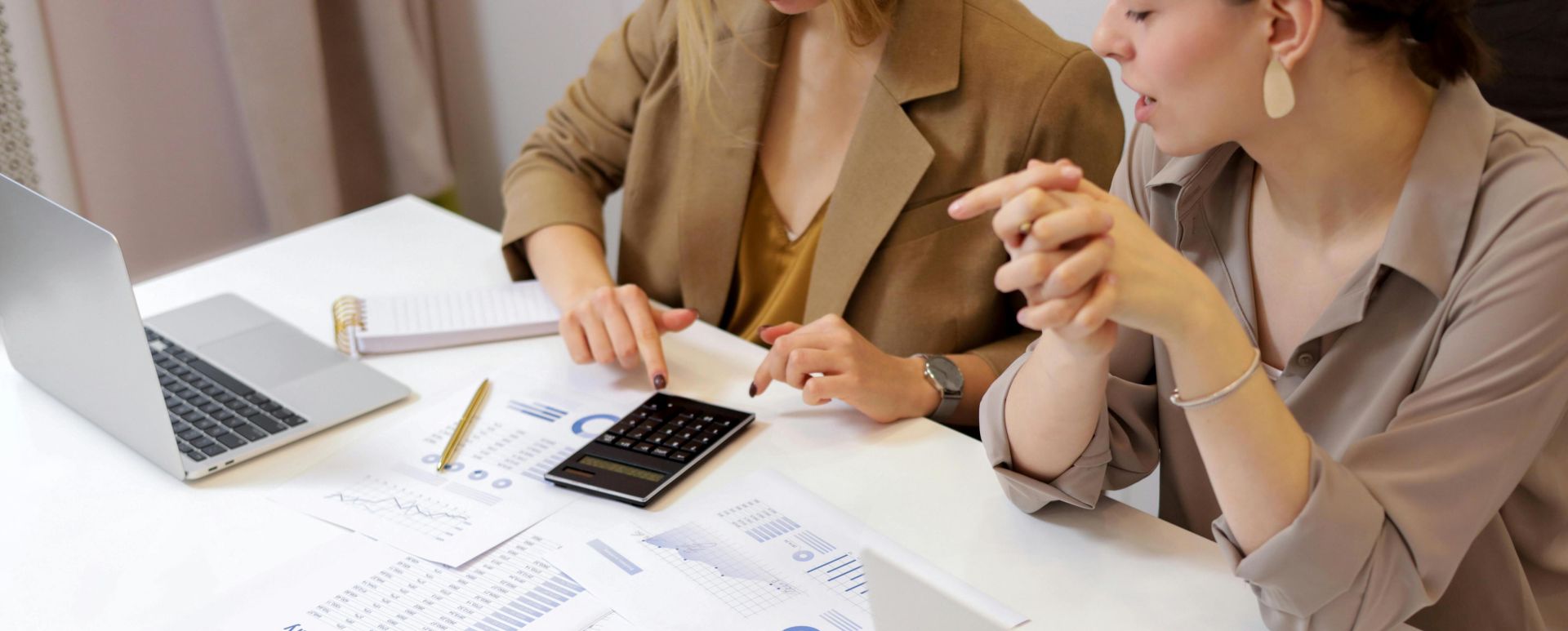 Two professionals collaborating on financial documents in a modern office setting.